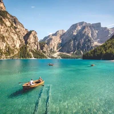 Barca en un lago turquesa rodeado de montañas