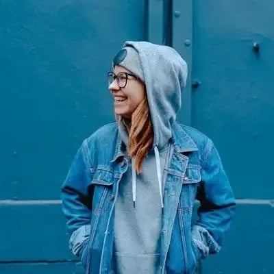 Retrato de una mujer con chaqueta vaquera delante de una pared azul
