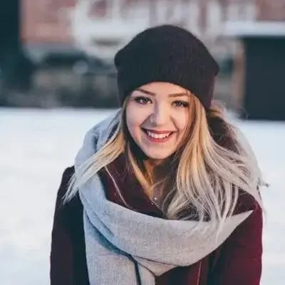 Retrato de una mujer sonriente con gorro y bufanda